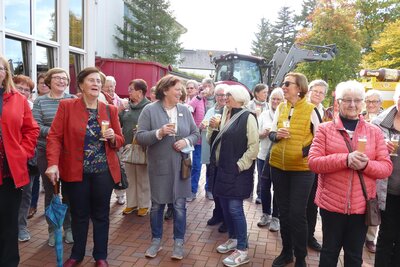 Landfrauen mit Begrüßungsdrink im Hintergrund wird Treber durch örtliche Landwirte abgeholt